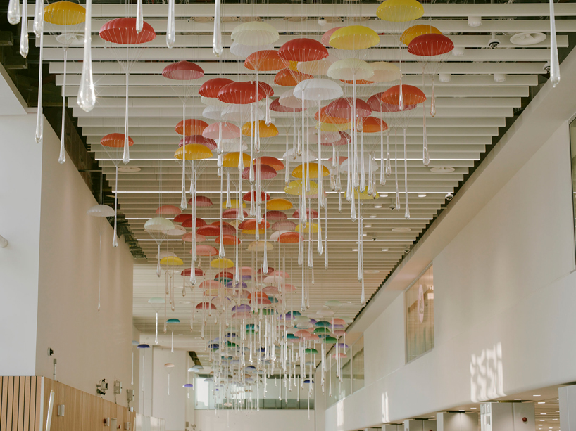 hundreds of suspended parachutes by lazerian drift above manchester airport’s terminal - 1