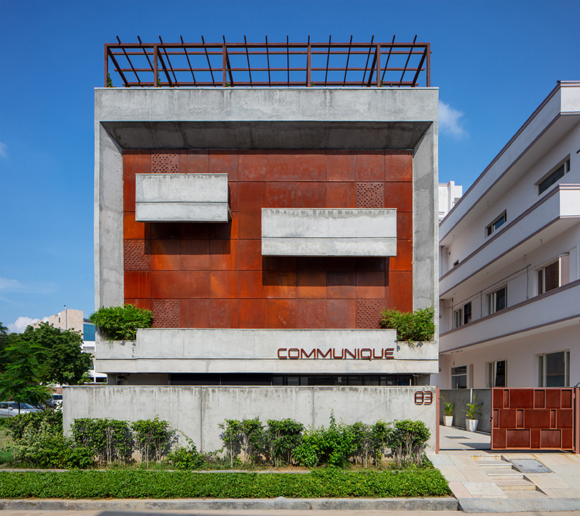 a brutalist concrete office building in india punctuated by corten steel, by groupDCA