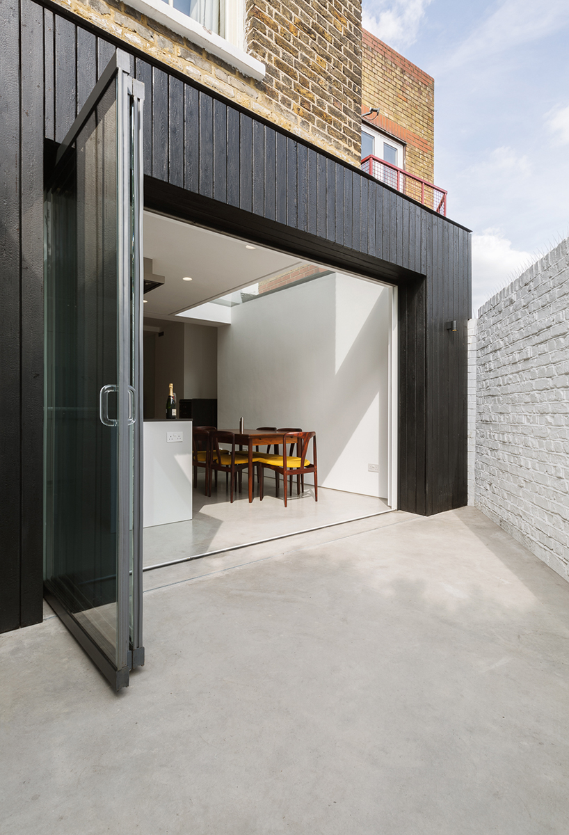 dickson architects extends a victorian house with black timber box