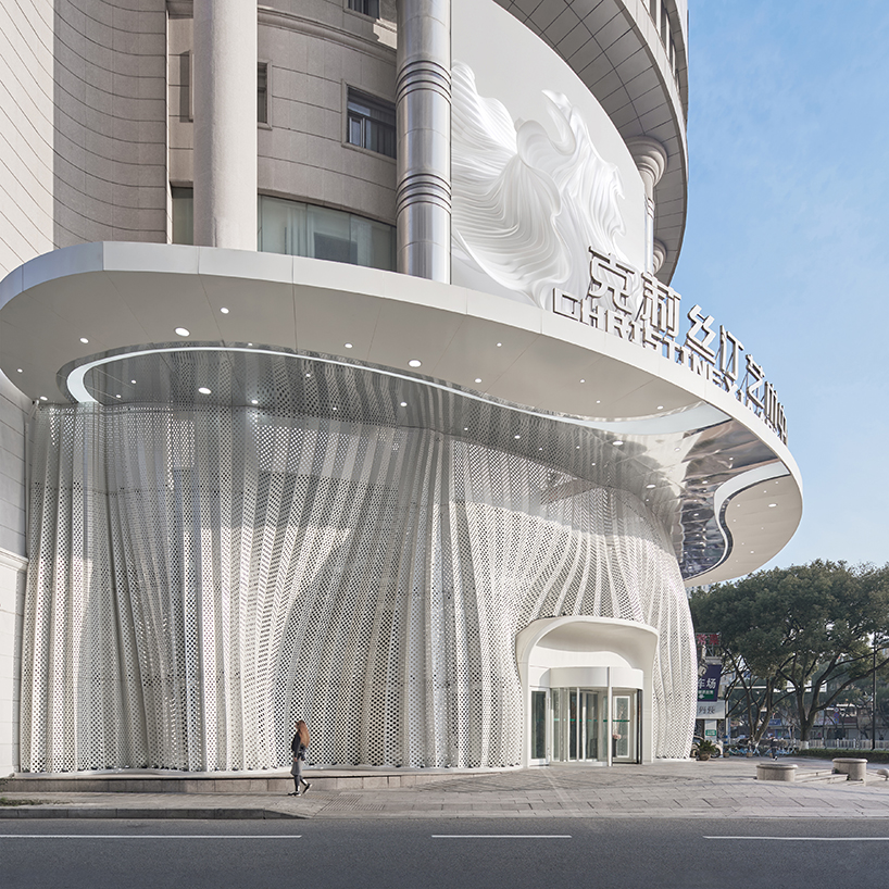 antistatics architecture echoes rippling fabric in perforated metal at wedding center in china