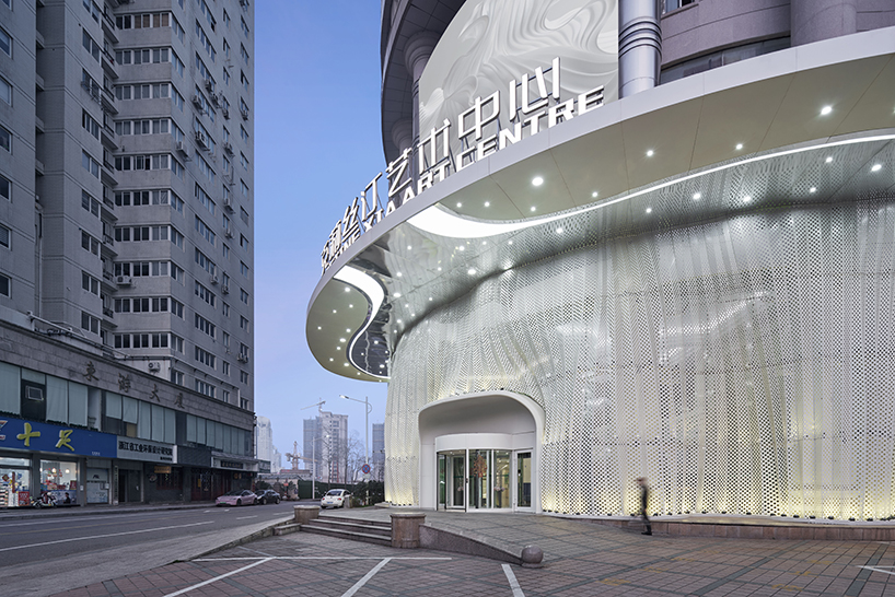 antistatics architecture echoes rippling fabric in perforated metal at wedding center in china