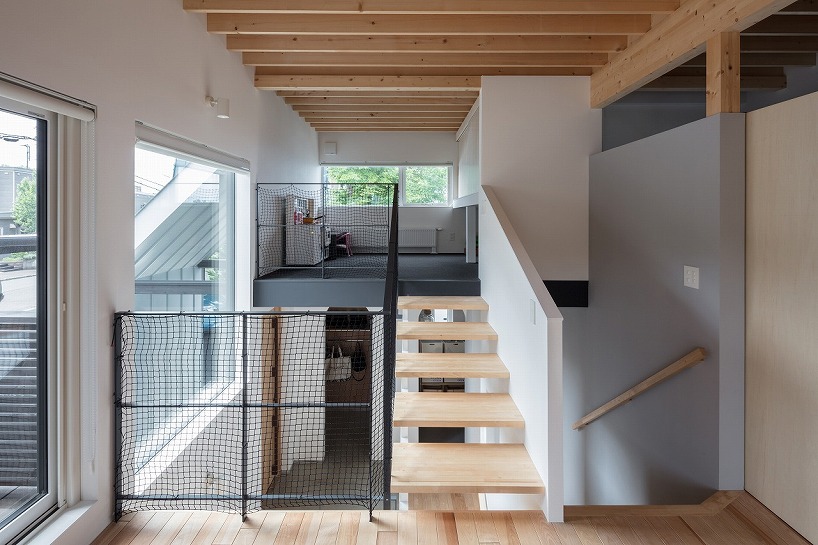 quatre étages de terrasse interconnectés se développent autour de l'atrium de la maison au Japon
