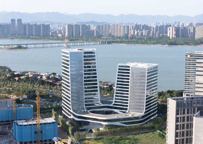 curving towers of LYCS architecture's mixed-use complex echo ripples of wulong river, china