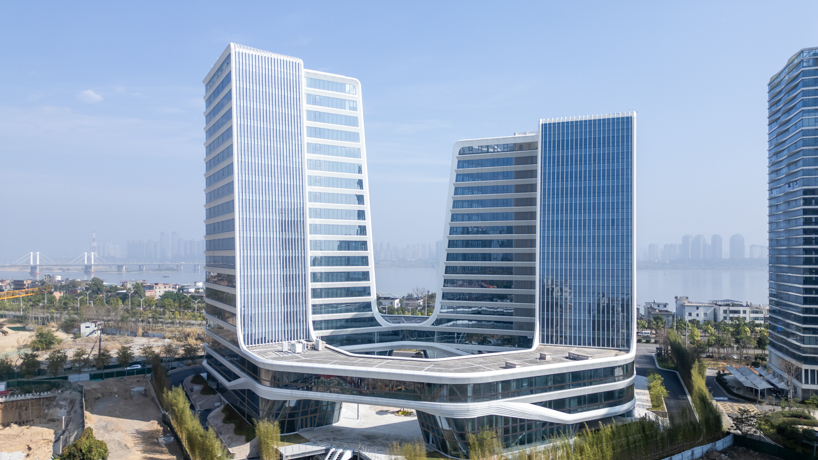 curving towers of LYCS architecture's mixed-use complex echo ripples of wulong river, china