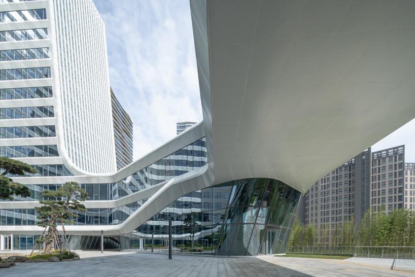 curving towers of LYCS architecture's mixed-use complex echo ripples of wulong river, china