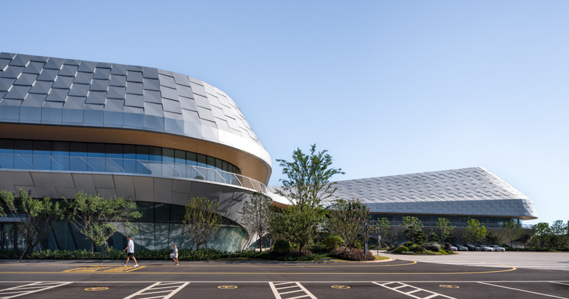 La pared exterior en forma de escala envuelve la forma ondulada del Centro de Natación de Guangshan, de Lycs Architecture