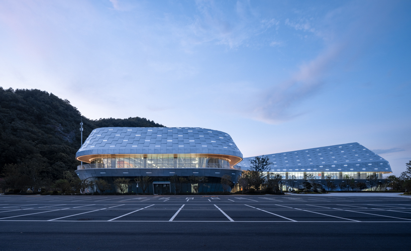 scale-like facade wraps hushan swimming center's undulating form by LYCS architecture