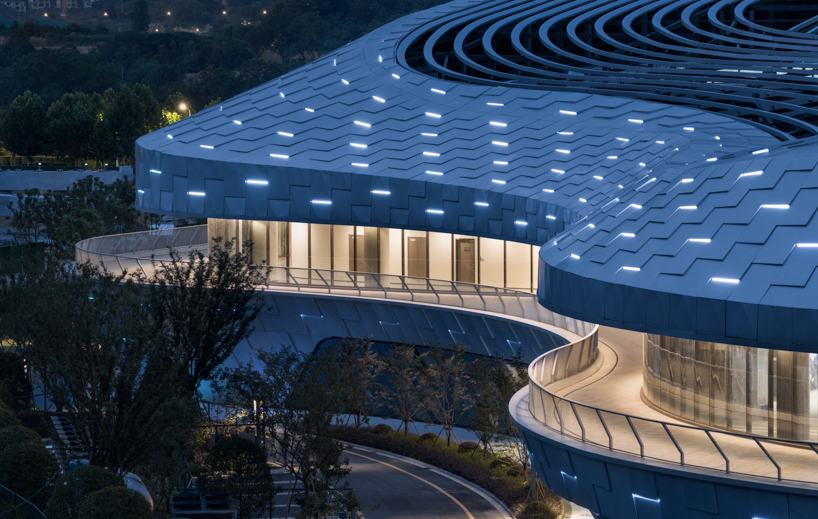 scale-like facade wraps hushan swimming center's undulating form by LYCS architecture