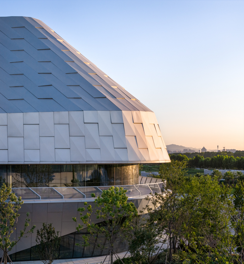 scale-like facade wraps hushan swimming center's undulating form by LYCS architecture
