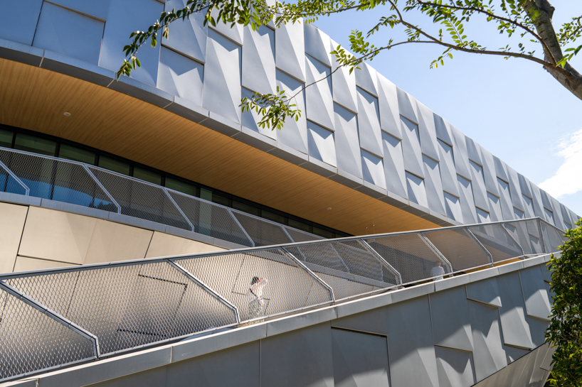 scale-like facade wraps hushan swimming center's undulating form by LYCS architecture