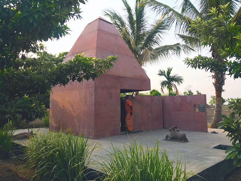 karan darda's orange hindu temple in india creates a contrast with green surroundings