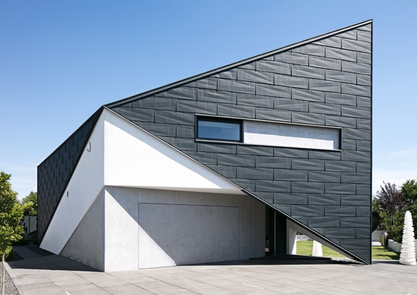 reform architekt's triangular house in poland perfectly fits surrounding environment