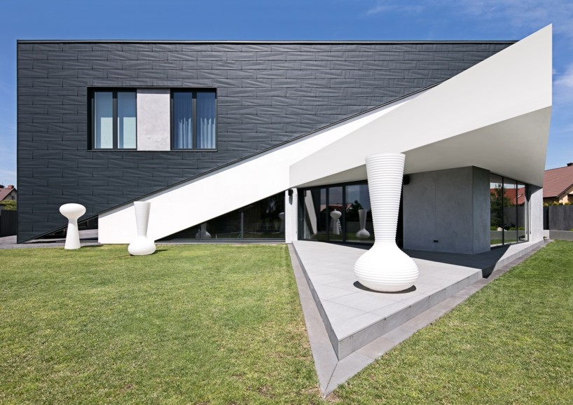 reform architekt's triangular house in poland perfectly fits surrounding environment