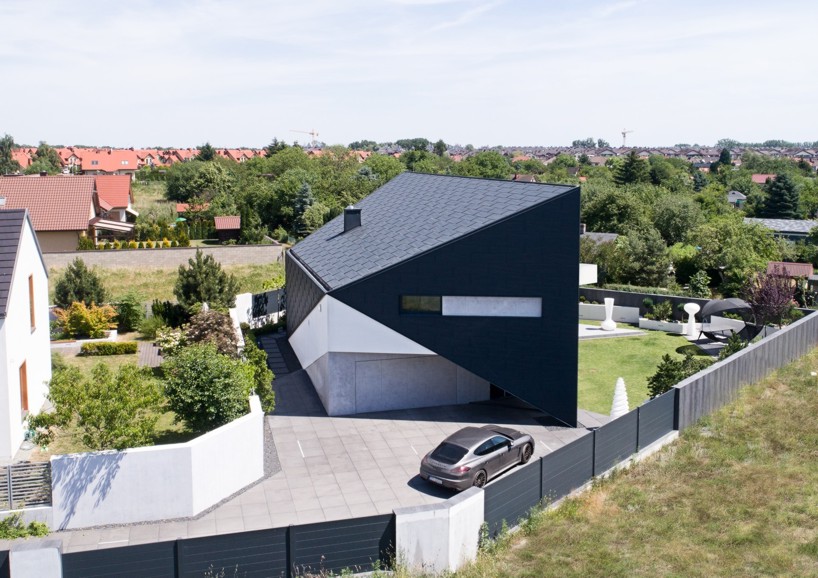 reform architekt's triangular house in poland perfectly fits surrounding environment