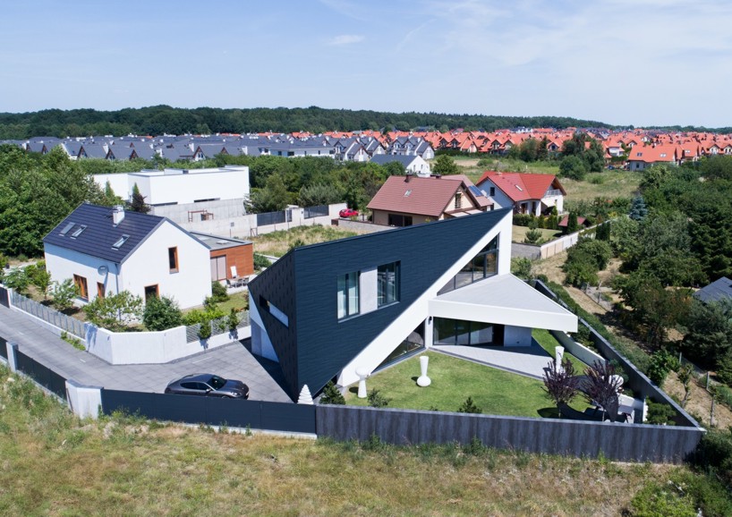 reform architekt's triangular house in poland perfectly fits surrounding environment