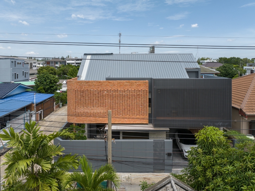 exposed brick wraps residence's facade by bodinchapa architects in bangkok