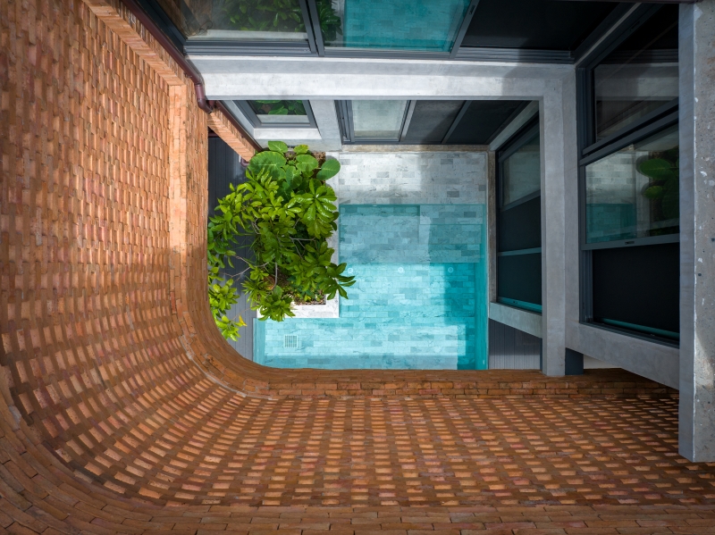 exposed brick wraps residence's facade by bodinchapa architects in bangkok