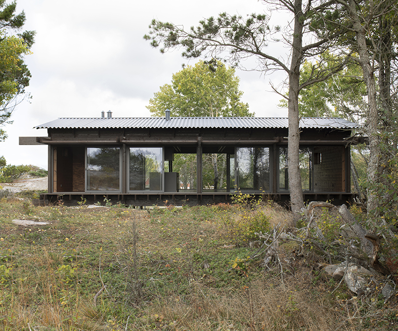 a grid of stained dark planks shapes up wooden cabin in west sweden