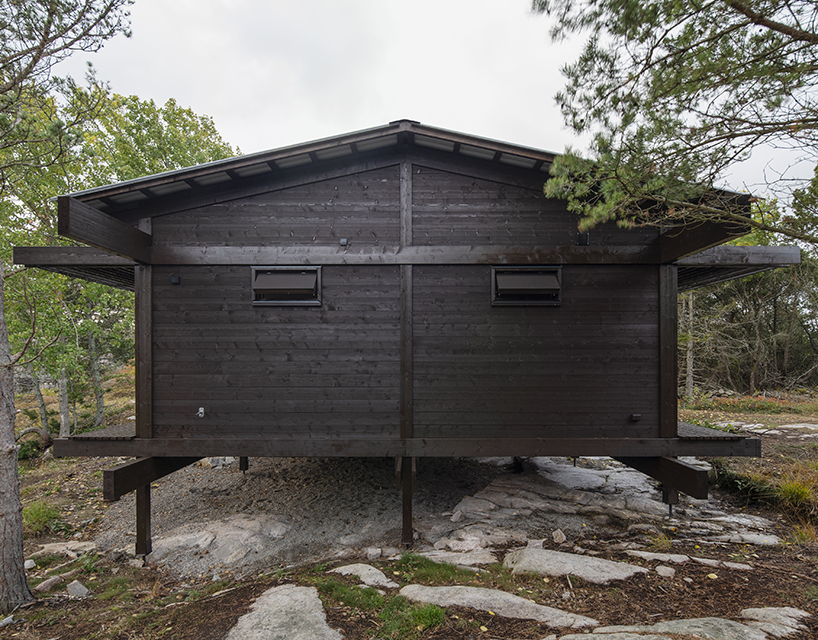 a grid of stained dark planks shapes up wooden cabin in west sweden