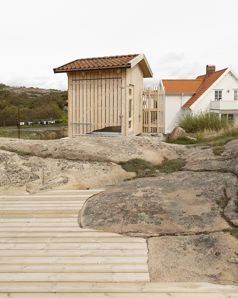 Un revestimiento de madera sin tratar envuelve la sauna vernácula de Sövall en la costa rocosa de Suecia