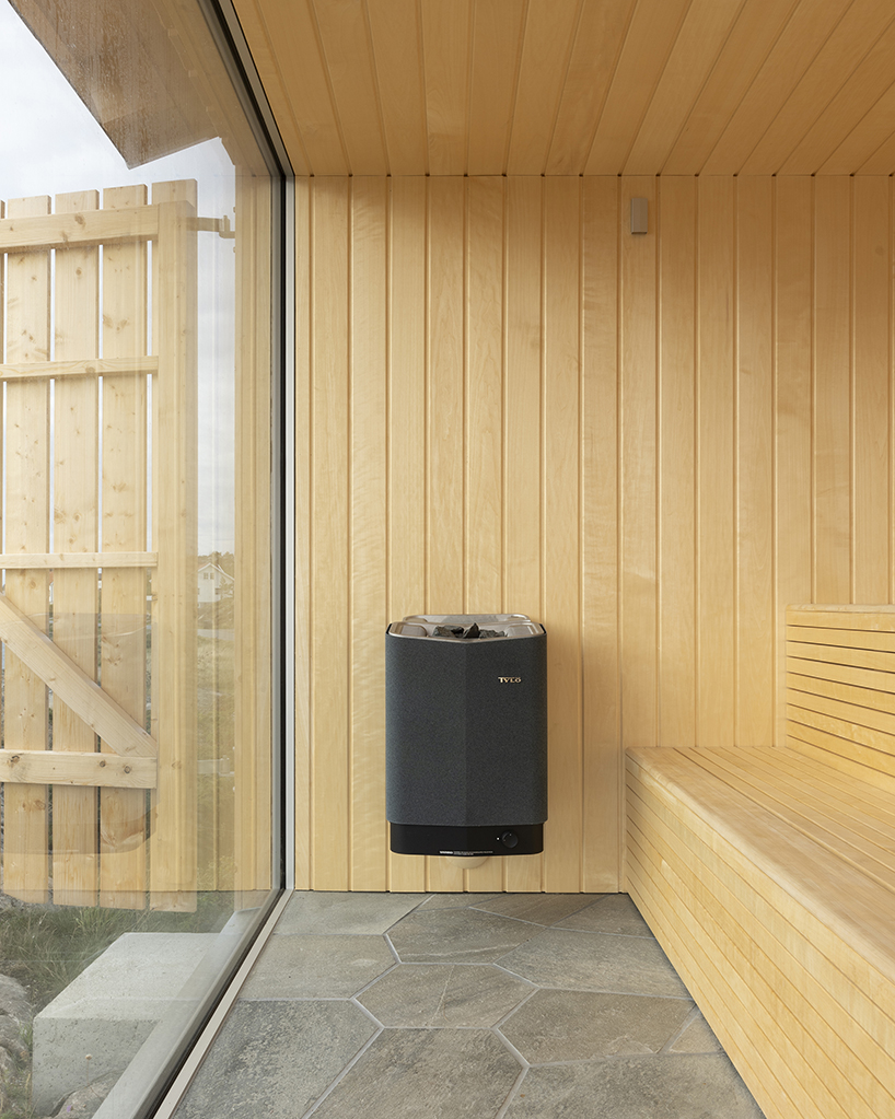 untreated wooden cladding wraps vernacular sauna sövall on sweden's rocky shoreline