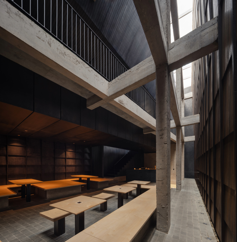 light and rain pour through internal courtyard within monochrome dessert shop in indonesia