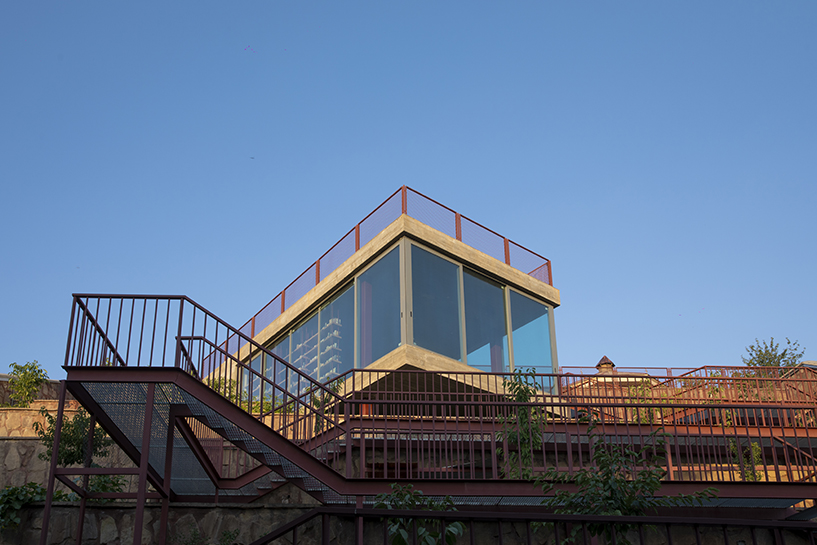 La oficina ayeneh, con sede en Teherán, diseña una estantería suspendida para flotar dentro del volumen de vidrio de la villa