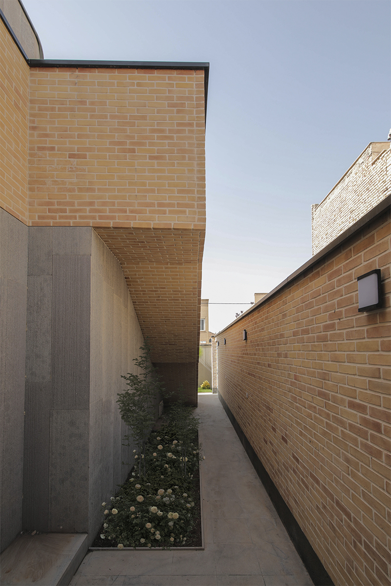 des vides lumineux percent une maison en brique d'Annab en Iran