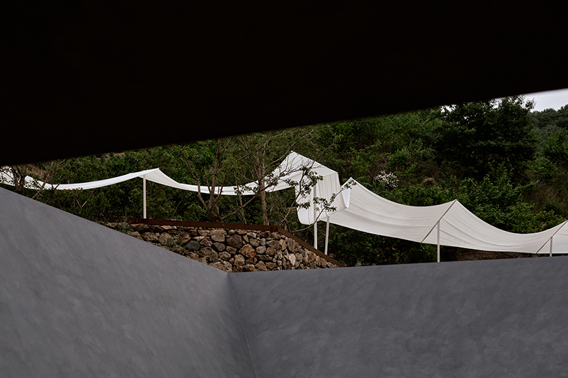 team_bldg's white gauze installation flutters and chimes soft bells in ancient valley in china