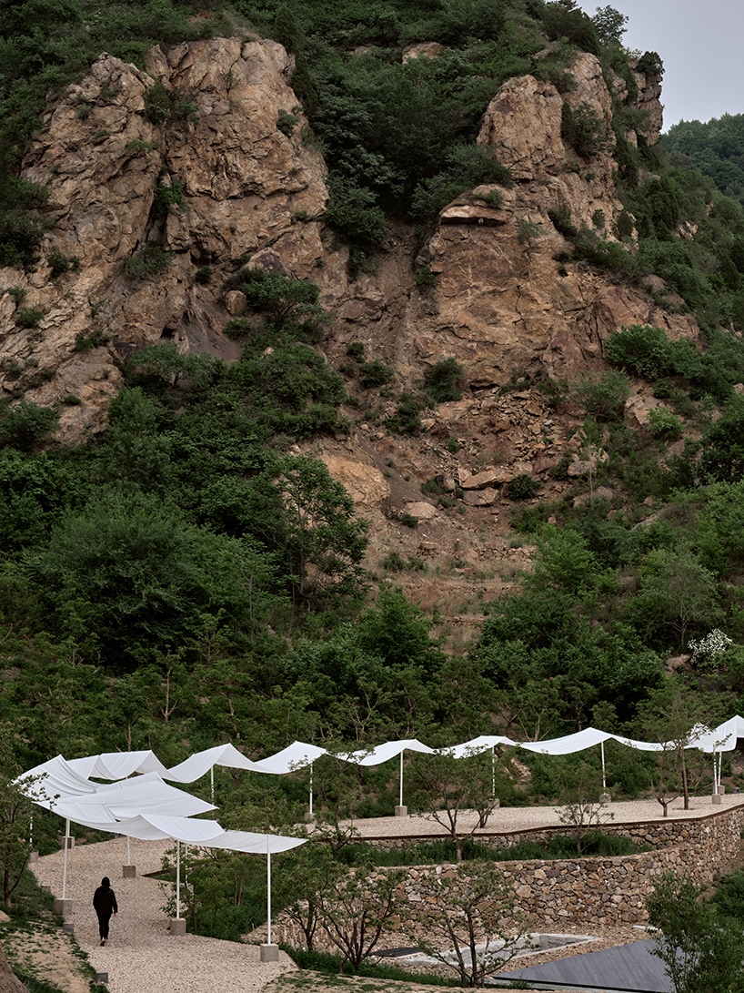 team_bldg's white gauze installation flutters and chimes soft bells in ancient valley in china