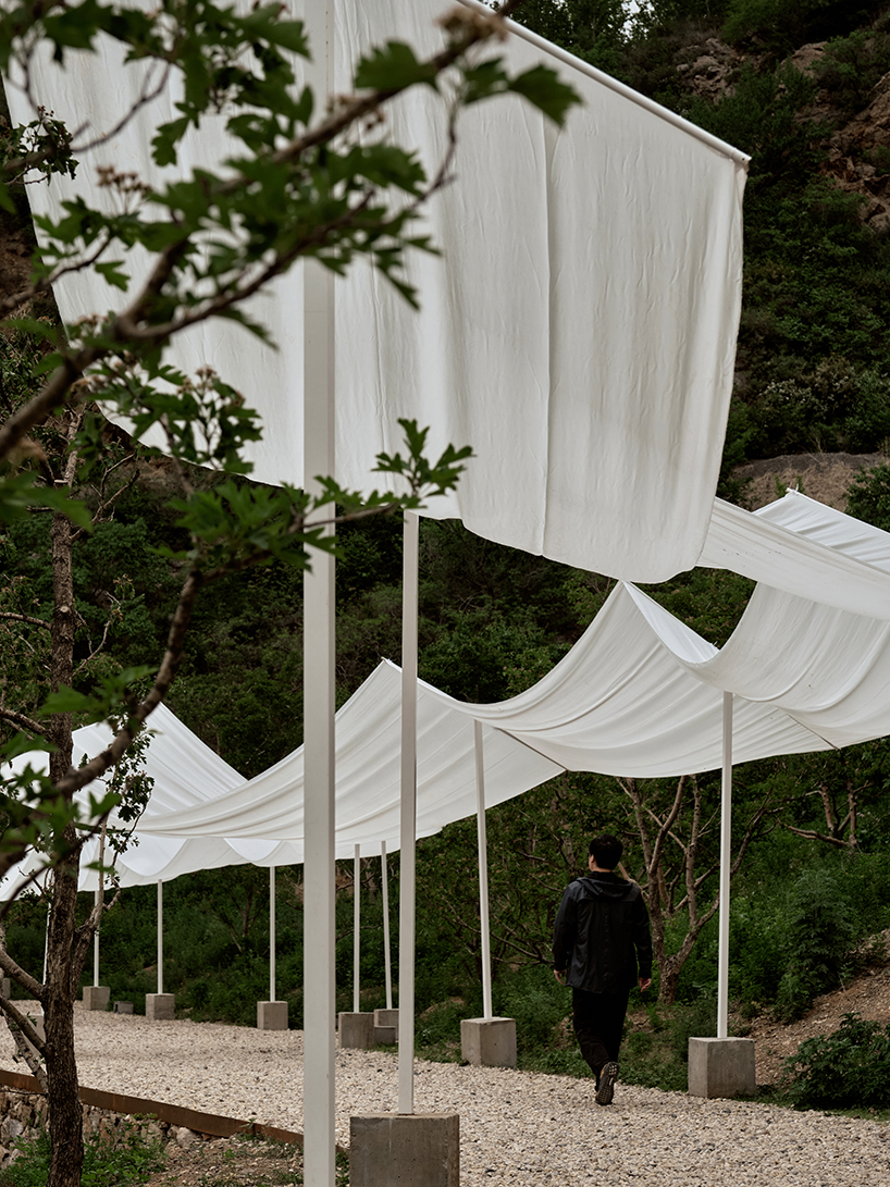 team_bldg's white gauze installation flutters and chimes soft bells in ancient valley in china