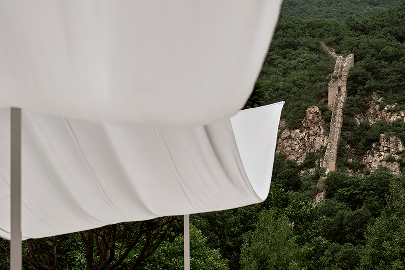 team_bldg's white gauze installation flutters and chimes soft bells in ancient valley in china