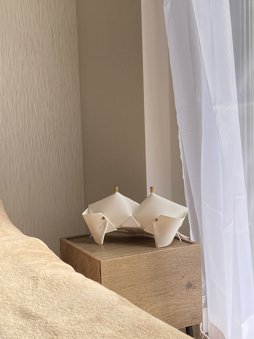 La lámpara de cangrejo de origami se pliega y se convierte en una mesita de noche que emite un brillo suave.