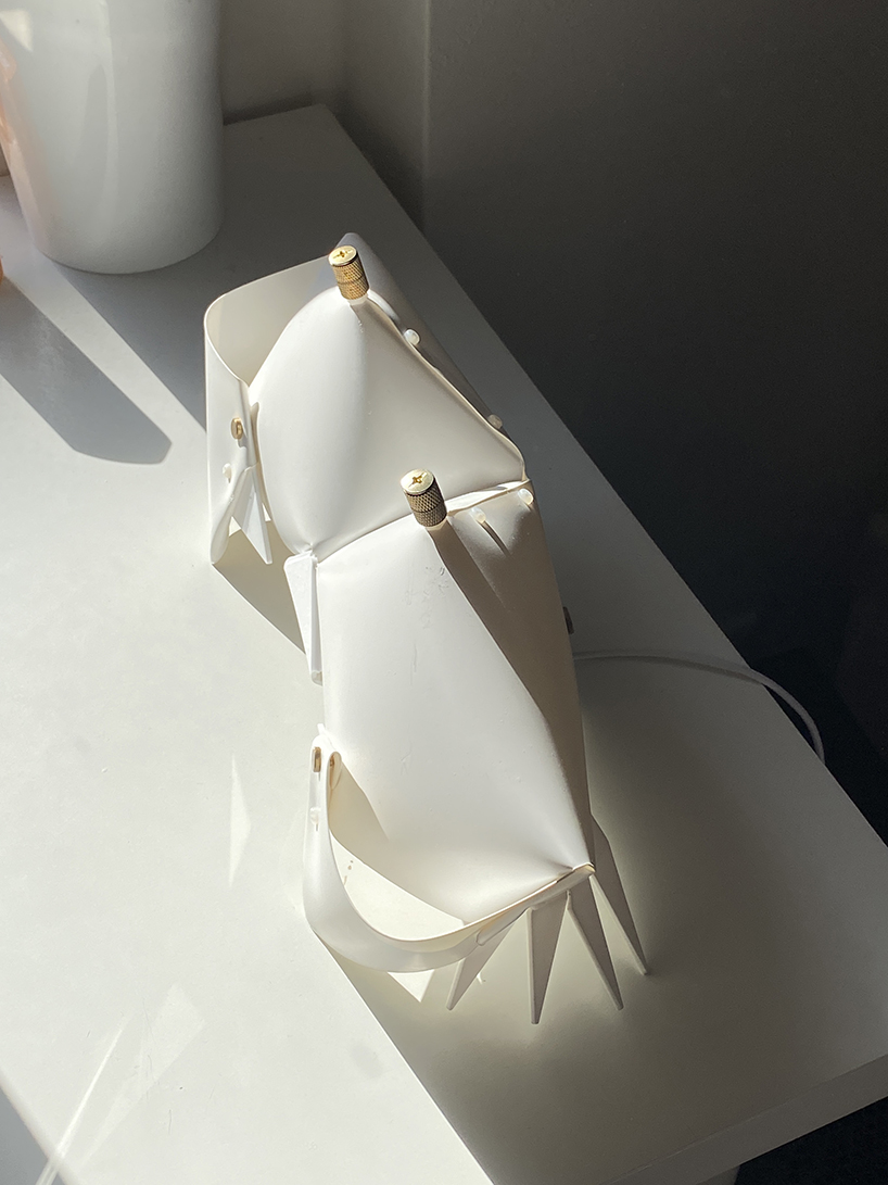 La lámpara de cangrejo de origami se pliega y se convierte en una mesita de noche que emite un brillo suave.