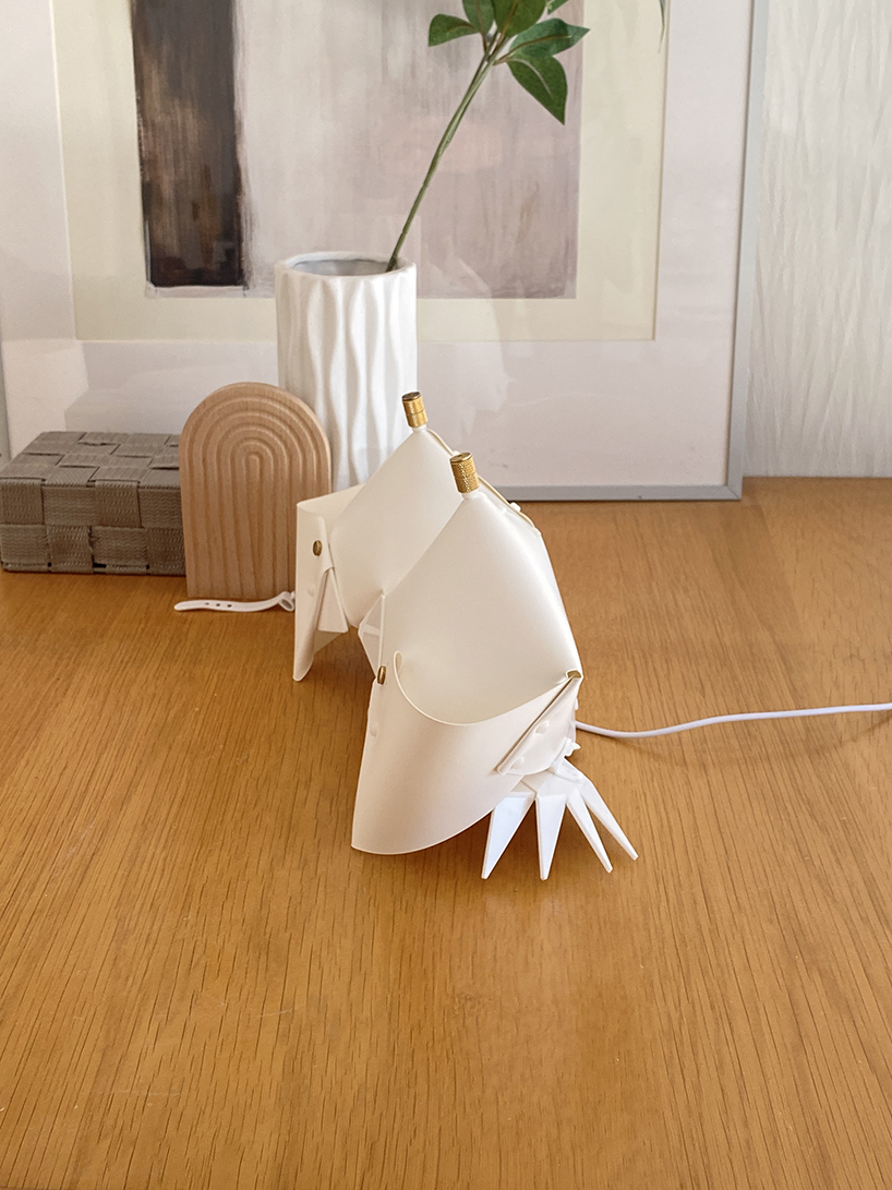 La lámpara de cangrejo de origami se pliega y se convierte en una mesita de noche que emite un brillo suave.