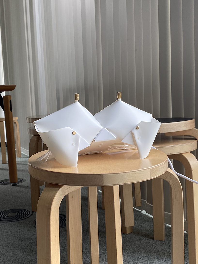 La lámpara de cangrejo de origami se pliega y se convierte en una mesita de noche que emite un brillo suave.