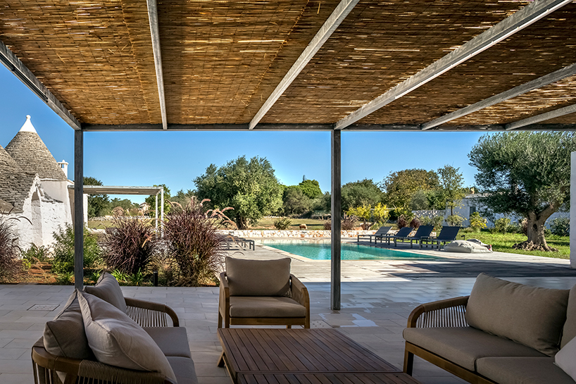 reisarchitettura's L-shaped extension completes traditional stone house with six trulli in italy