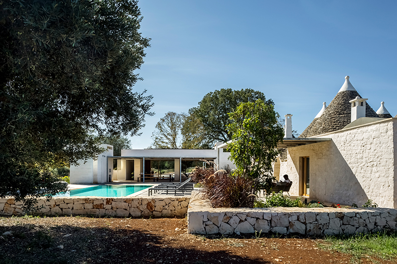 reisarchitettura's L-shaped extension completes traditional stone house with six trulli in italy