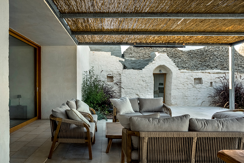 reisarchitettura's L-shaped extension completes traditional stone house with six trulli in italy