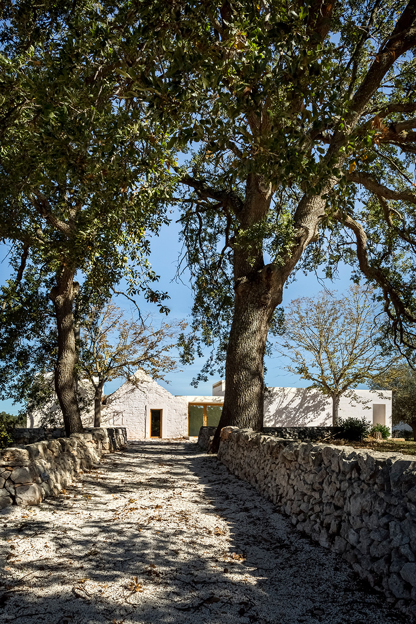 reisarchitettura's L-shaped extension completes traditional stone house with six trulli in italy