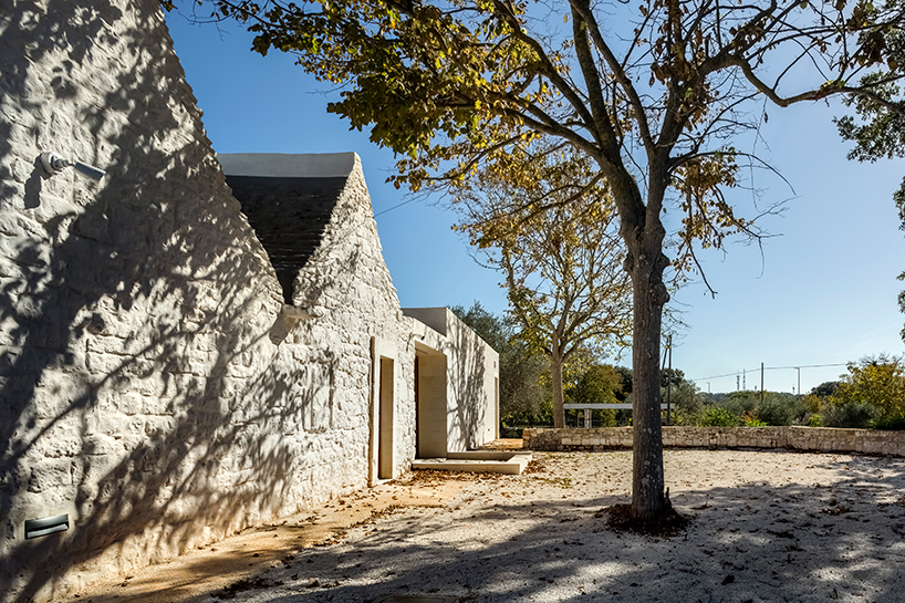 reisarchitettura's L-shaped extension completes traditional stone house with six trulli in italy