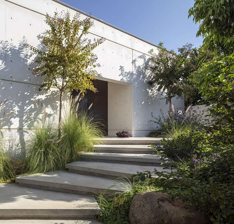 off white concrete facade creates maximum privacy for this tel aviv house 11