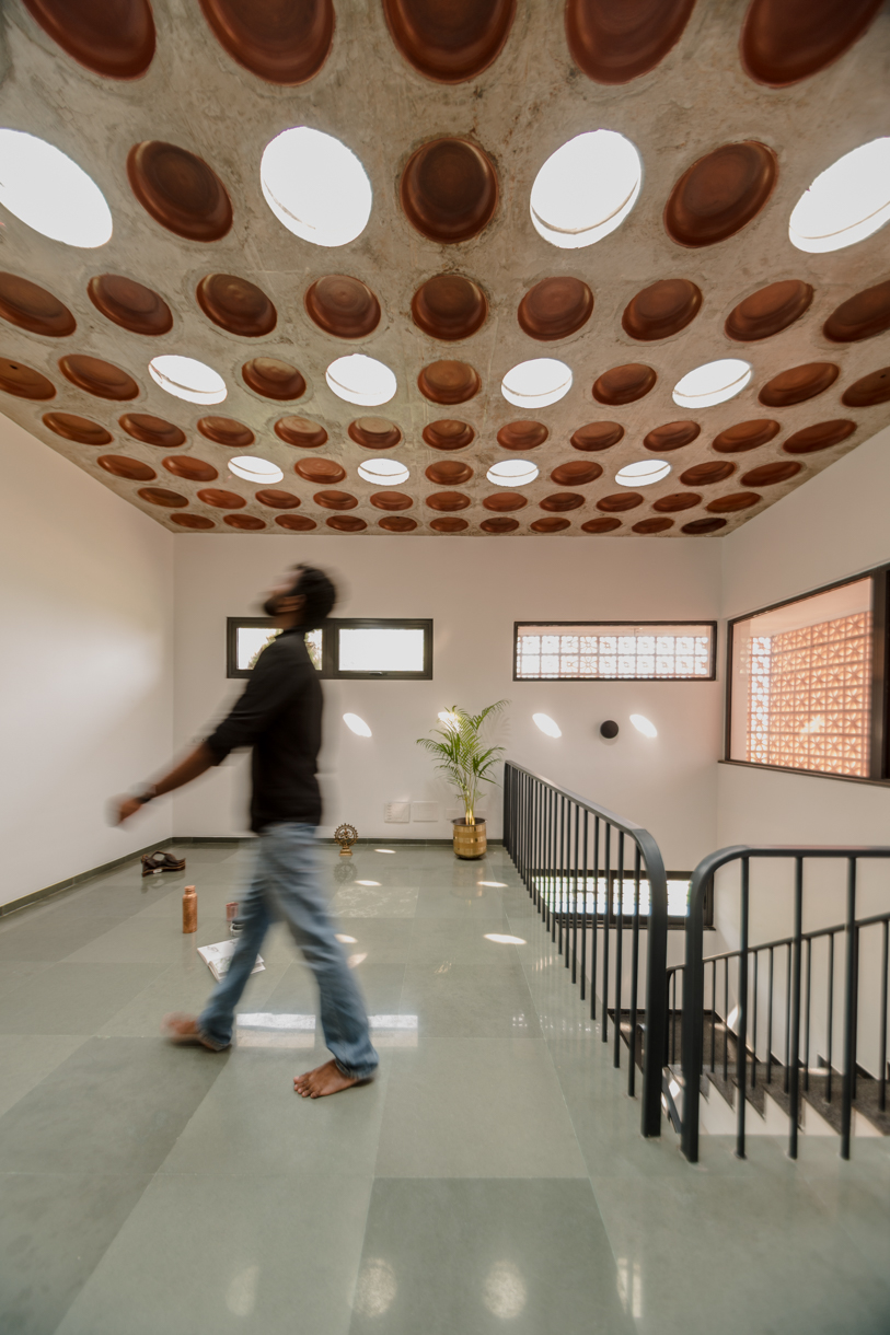 STO.M.P applies terracotta façade and earthy materials to 'house in a grove' in india