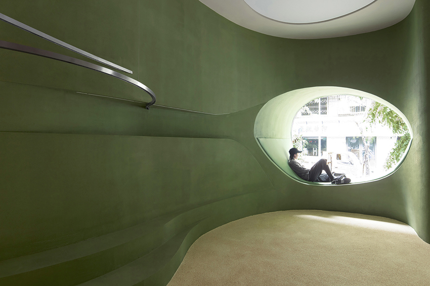 irregular curves bring the nature inside this pastel green café in china 