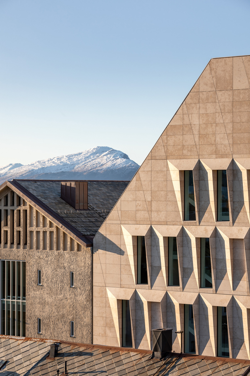 studio ALL's faceted stone facade plays with light on city hall in norway