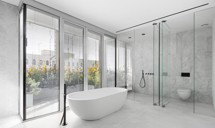 yoma architects clads luxury penthouse in marble and brass detailing in jerusalem