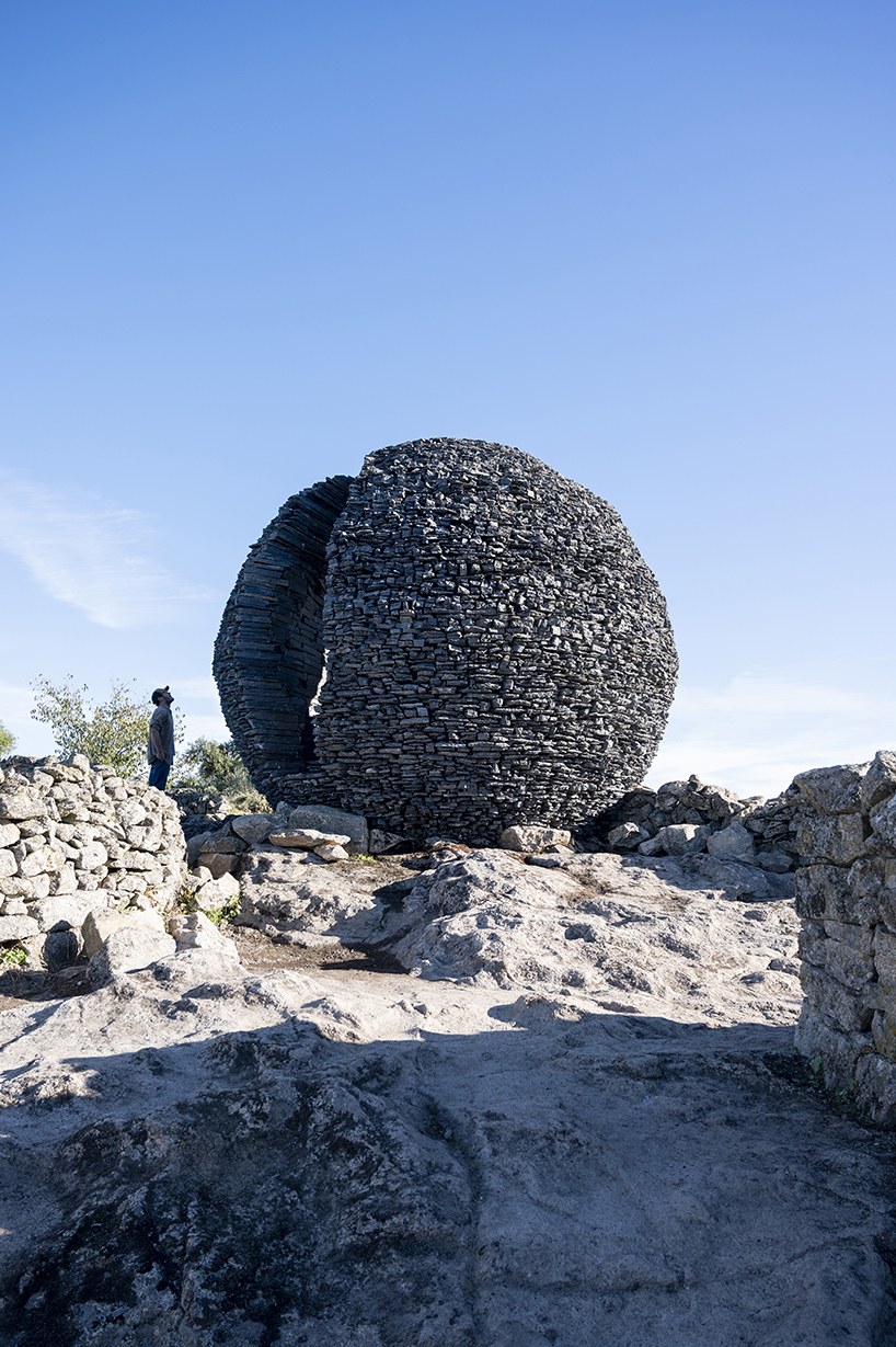 atelier yokyok sculpts sphere land installation out of black schist and granite in portugal