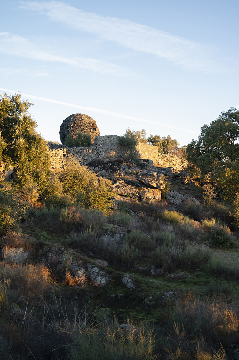 atelier yokyok sculpts sphere land installation out of black schist and granite in portugal