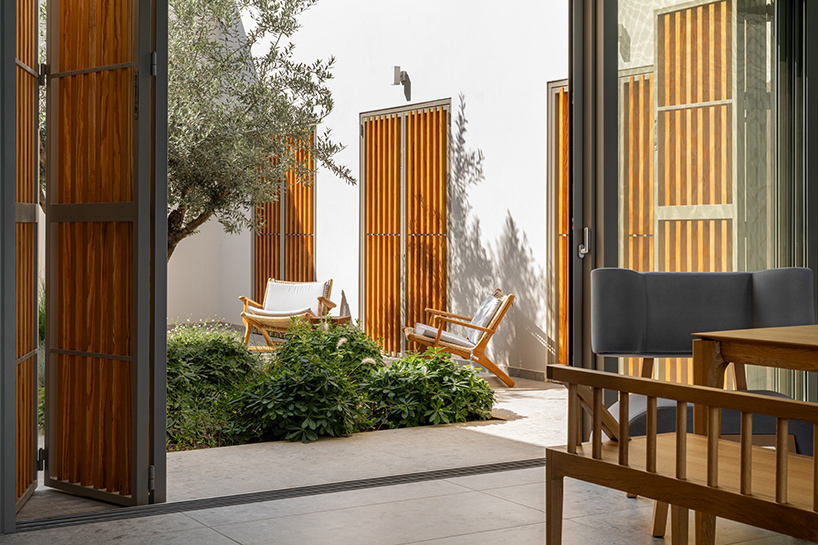 pieris.architects embeds layered stone-and-plaster residence into greek hillside