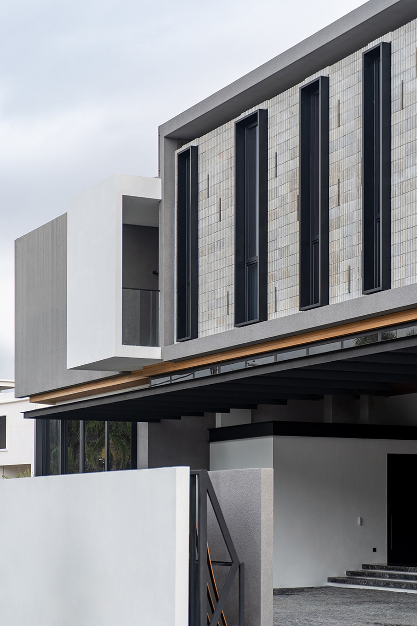 fluted concrete blocks extend 3-juxta house's facade towards streetfront in malaysia